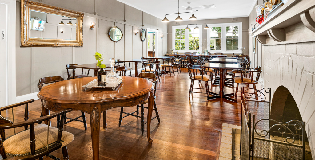 Main dining room features hardwood floors and an open fireplace